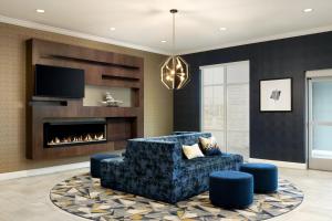a living room with a couch and a fireplace at Hyatt Select St Louis Airport in Saint Louis