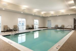 a large swimming pool with chairs and tables at Hyatt Select St Louis Airport in Saint Louis