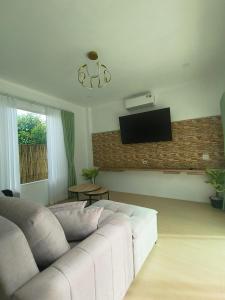 a living room with a white couch and a tv at Harmony Villa in Wok Tum