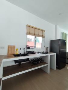 a kitchen with a sink and a refrigerator at Harmony Villa in Wok Tum