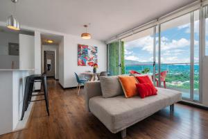 a living room with a couch and a large window at Torre Ambar Executive Residences in San José