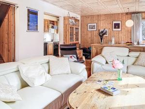 a living room with white couches and a wooden table at Chalet Chalet chemin du four by Interhome in Morgins +11 photos