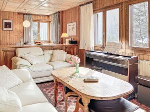 a living room with a couch and a piano at Chalet Chalet chemin du four by Interhome in Morgins