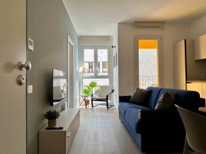 a living room with a blue couch and a table at Bressanone Apartments in Milan