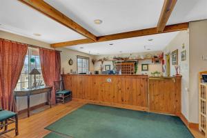 a living room with wooden paneling and a kitchen at Garrison Inn and Suites in Garrison