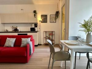 a living room with a red couch and a table at Bressanone Apartments in Milan