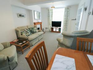a living room with a couch and chairs and a table at 23 Beach Road in Y Felinheli