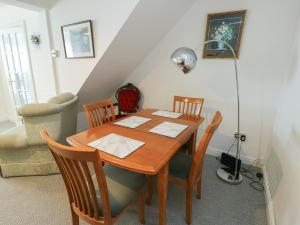a dining room table with chairs and a lamp at 23 Beach Road in Y Felinheli