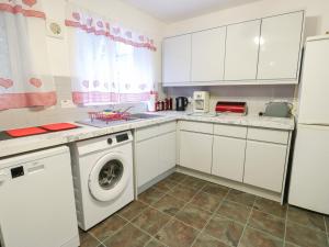 a kitchen with white cabinets and a washing machine at 23 Beach Road in Y Felinheli +17 photos