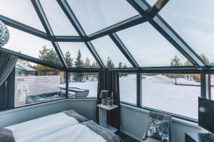 a bedroom with a large glass window and a bed at Santa's Igloos Arctic Circle in Rovaniemi