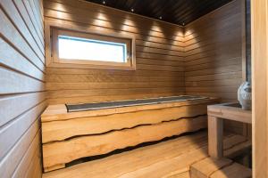 a sauna with a window and a wooden floor at Santa's Igloos Arctic Circle in Rovaniemi +8 photos