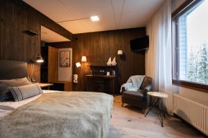 ein Schlafzimmer mit einem Bett, einem Stuhl und einem Fenster in der Unterkunft Santa's Hotel Aurora & Igloos in Luosto