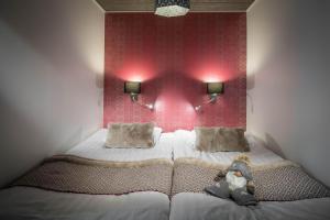 a bedroom with a bed with a red wall at Santa's Igloos Arctic Circle in Rovaniemi