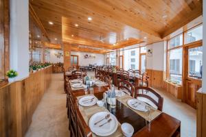 a dining room with wooden tables and chairs at Hotel SNAS Retreat Manali in Manāli