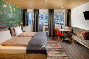 a hotel room with two beds and a desk at Eiger Guesthouse in Mürren