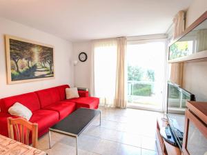 a living room with a red couch and a large window at Apartment Sa Guilla by Interhome in Pals