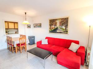 a living room with a red couch and a table at Apartment Sa Guilla by Interhome in Pals +20 photos