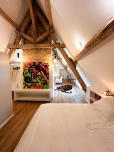 a loft bedroom with a painting on the wall at Château de Foussal in Issigeac +65 photos