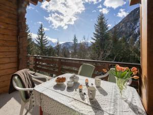 a table with a vase of flowers on a balcony at Chalet Veni- Vidi- Mansi by Interhome in Champex