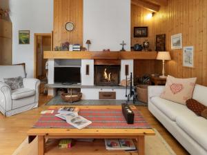 a living room with a fireplace and a table at Chalet Veni- Vidi- Mansi by Interhome in Champex