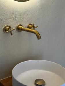 a bathroom sink with a gold faucet on a wall at Casa Cookie in Ojén
