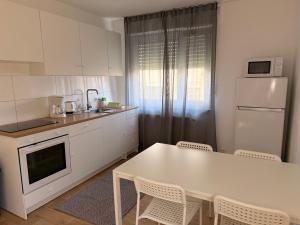 a white kitchen with a white table and chairs at Ferienwohnung Marktplatz in Oppenheim