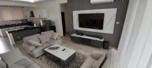 a living room with a couch and a tv at Easy stays baobab in Mombasa