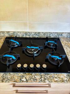 a black stove top with blue tops in a kitchen at Residence ocean view in Ngor