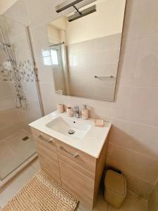 a bathroom with a sink and a shower and a mirror at Residence ocean view in Ngor
