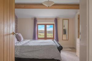 a bedroom with a bed and a window at Spacious Barn Conversion 4 Bedroom Hot Tub - Pass the Keys in Seathwaite
