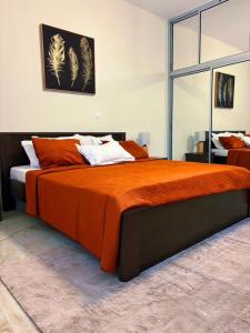 a bedroom with a large bed with an orange blanket at Residence ocean view in Ngor