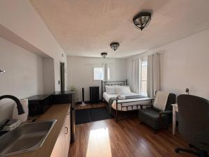 a kitchen with a sink and a bed in a room at Stone House Kenora in Kenora