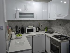 a kitchen with white cabinets and a stove top oven at Sarajevo Central View Apartment in Sarajevo