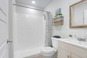 a white bathroom with a toilet and a sink at The Container Retreat - 2A in Canyon Lake