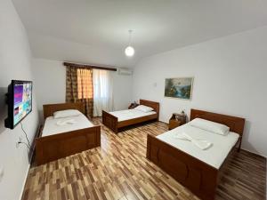 a room with two beds and a flat screen tv at ES Berat Apartments in Berat