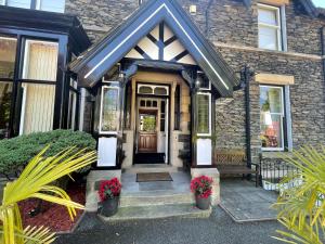 a brick house with a front door with flowers at Beaumont Windermere - Adults-Only Boutique Guest House- Free Parking & Wellness Access in Windermere