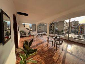 a large room with tables and chairs on a balcony at ES Berat Apartments in Berat
