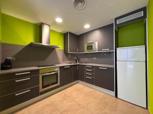 a kitchen with black cabinets and green walls at Casa Polaco in Valderrobres
