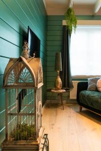 a room with a bird cage in a living room at Stijl en kleur in Diest