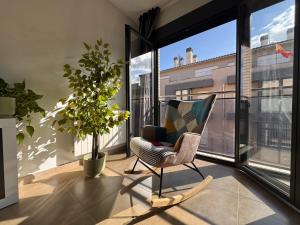 a chair in a room with a large window at Casa Polaco in Valderrobres