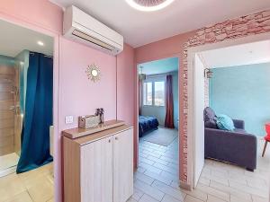 a living room with pink walls and a mirror at Apartment U Centru by Interhome in Porto-Vecchio