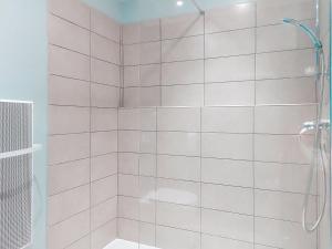 a bathroom with a shower with white tiles at Apartment U Centru by Interhome in Porto-Vecchio