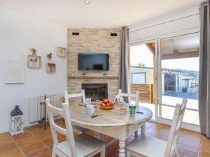 a dining room with a table and a fireplace at Villa Can Gordei by Interhome in Albinyana