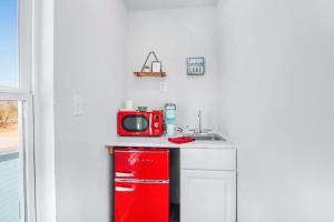 a small kitchen with a red microwave on a counter at The Container Retreat - 3B in Canyon Lake +5 photos