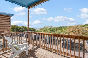 a deck with a chair and a view of the water at The Container Retreat - 3B in Canyon Lake