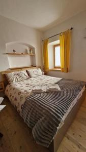a bedroom with a large bed with yellow curtains at Casa di Chiara in Padola