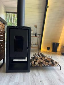 a fireplace with a pile of fire wood next to it at Cabana Encanto A-FRAME Com Cachoeira in Bocaina de Minas