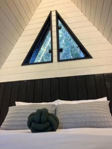 a room with a bed with a window on it at Cabana Encanto A-FRAME Com Cachoeira in Bocaina de Minas