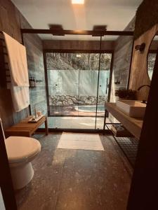 a bathroom with a toilet and a sink and a tub at Cabana Encanto A-FRAME Com Cachoeira in Bocaina de Minas +25 photos