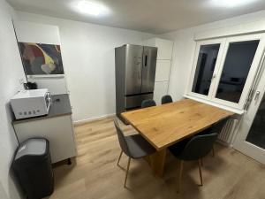 a kitchen with a wooden table and a refrigerator at Monteurswohnung Schwarzwald in Eggingen